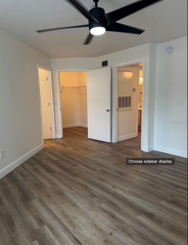 7280 Westpointe Blvd Unit 823, Orlando, FL 32835 - unfurnished bedroom featuring wood finished floors, a spacious closet, and ceiling fan