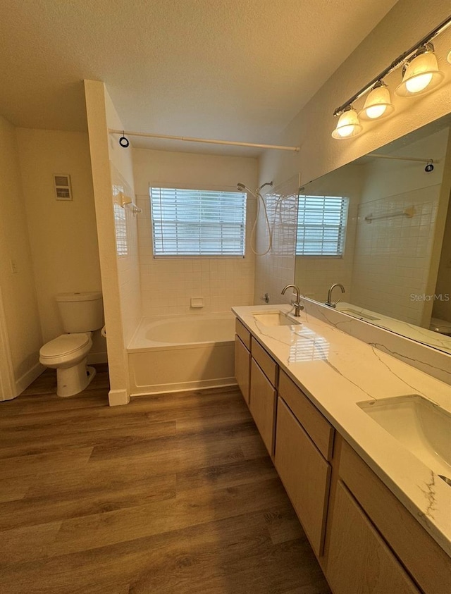 7280 Westpointe Blvd Unit 823, Orlando, FL 32835 - bathroom with bathtub / shower combination, wood finished floors, double vanity, and a textured ceiling