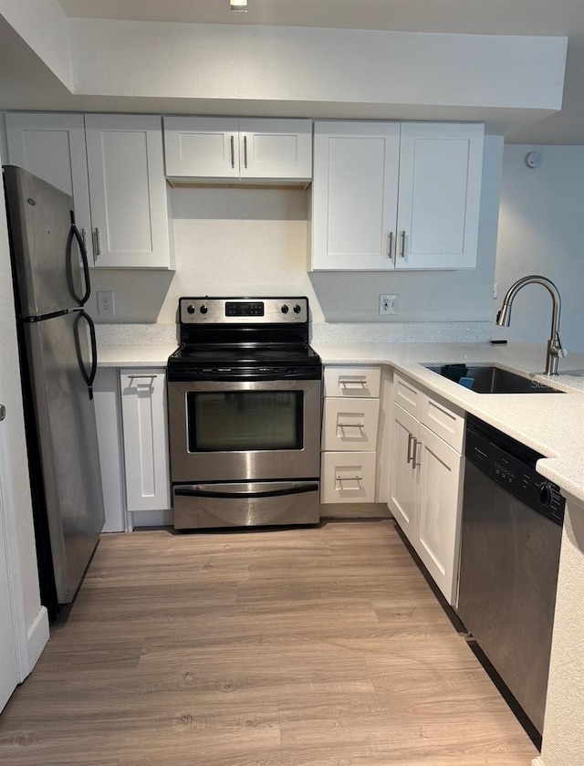 7280 Westpointe Blvd Unit 823, Orlando, FL 32835 - kitchen featuring stainless steel appliances, light countertops, white cabinetry, and light wood-type flooring