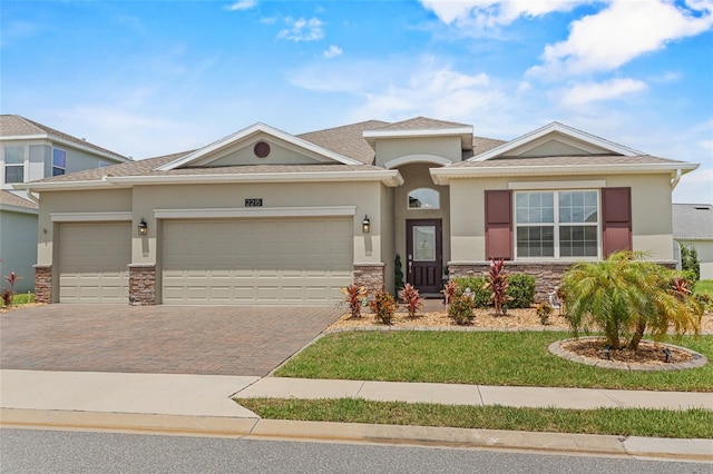 2215 Camden Park Ave, Davenport, FL 33837 - view of front of property featuring stone siding, driveway, a garage, and stucco siding