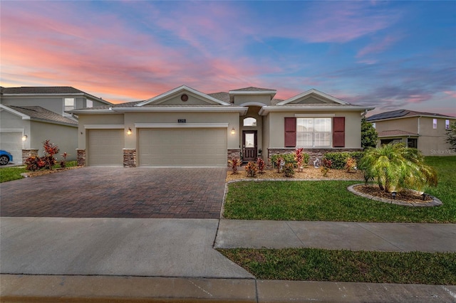 2215 Camden Park Ave, Davenport, FL 33837 - view of front of house with stucco siding, stone siding, driveway, and a garage