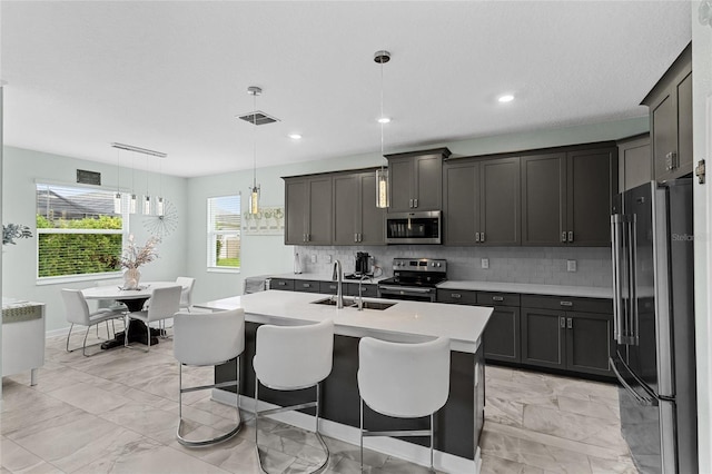 2215 Camden Park Ave, Davenport, FL 33837 - kitchen featuring appliances with stainless steel finishes, light countertops, light marble finish floors, decorative backsplash, and hanging light fixtures