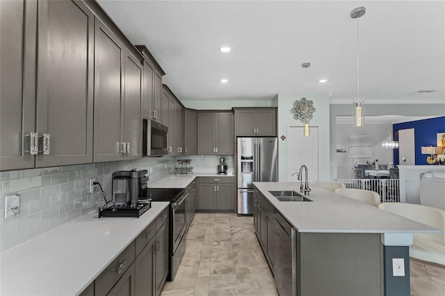 2215 Camden Park Ave, Davenport, FL 33837 - kitchen with light marble finish floors, appliances with stainless steel finishes, a kitchen island with sink, light countertops, and tasteful backsplash