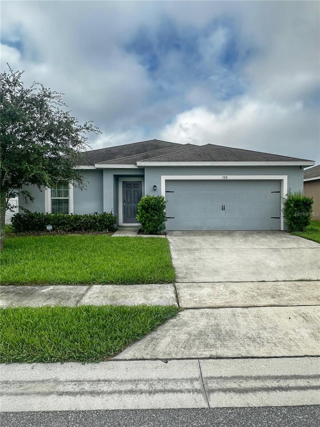388 Rooks Loop, Haines City, FL 33844 - ranch-style house with stucco siding, a garage, concrete driveway, and a front yard