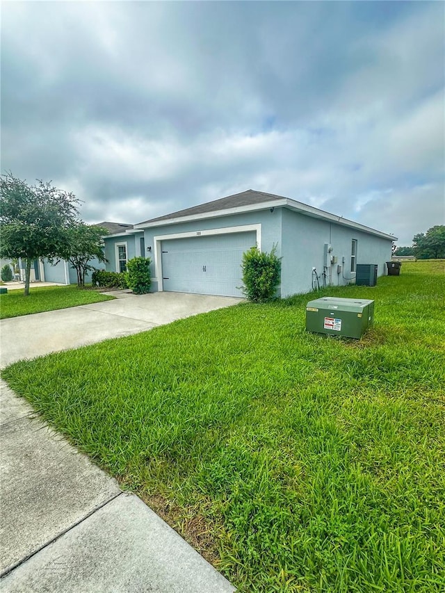 388 Rooks Loop, Haines City, FL 33844 - view of front of home featuring stucco siding, driveway, an attached garage, and a front yard