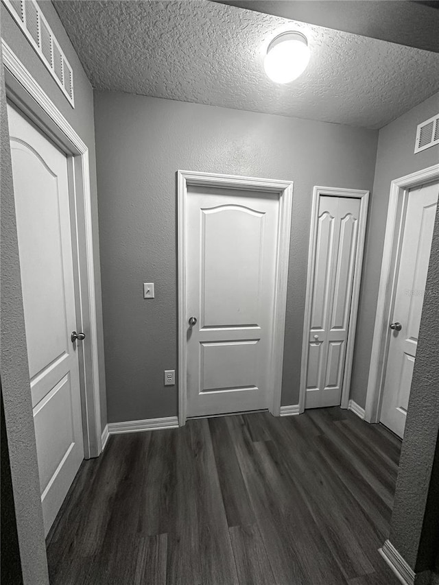 388 Rooks Loop, Haines City, FL 33844 - corridor with dark wood-style floors and a textured ceiling