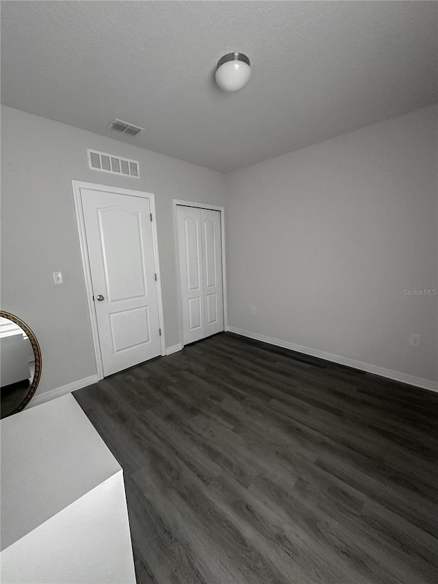 388 Rooks Loop, Haines City, FL 33844 - unfurnished bedroom featuring dark wood-style flooring and a closet