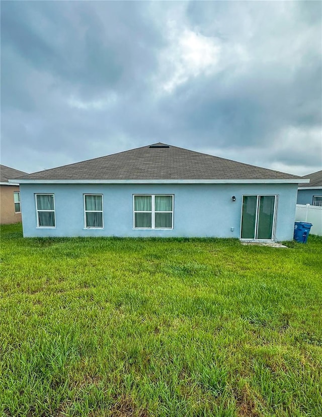 388 Rooks Loop, Haines City, FL 33844 - back of property featuring stucco siding and a lawn