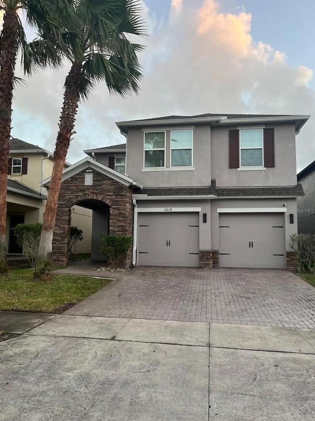 2618 San Simeon Way, Kissimmee, FL 34741 - traditional home with stucco siding, stone siding, decorative driveway, and a garage