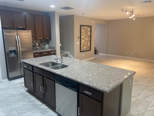 2618 San Simeon Way, Kissimmee, FL 34741 - kitchen featuring appliances with stainless steel finishes, a kitchen island with sink, open floor plan, light marble finish floors, and tasteful backsplash