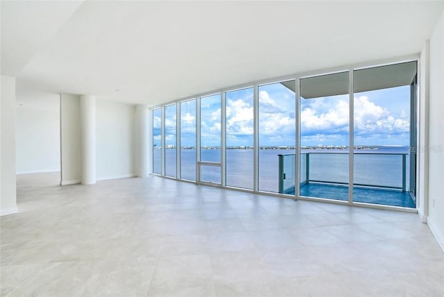 empty room with expansive windows and a water view