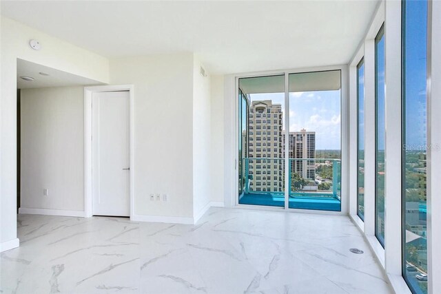 empty room featuring a wall of windows and a wealth of natural light