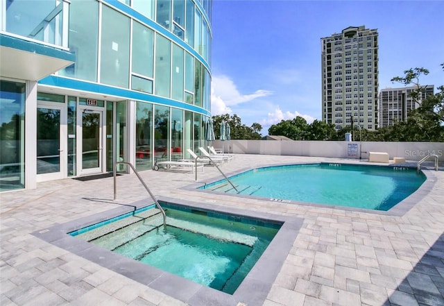 view of pool featuring a patio and a hot tub