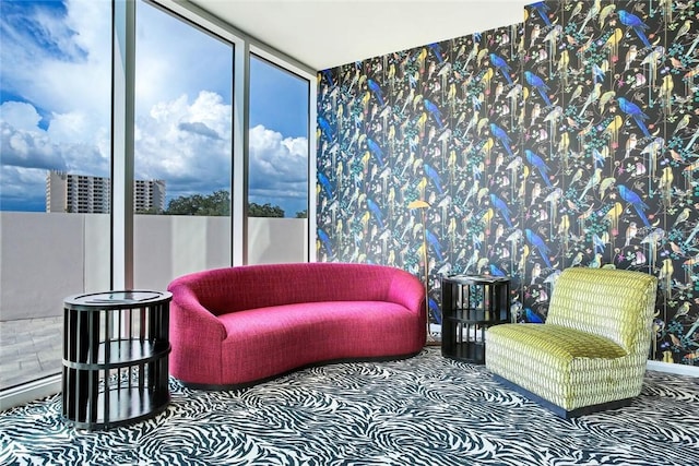 sitting room featuring a wall of windows and carpet flooring