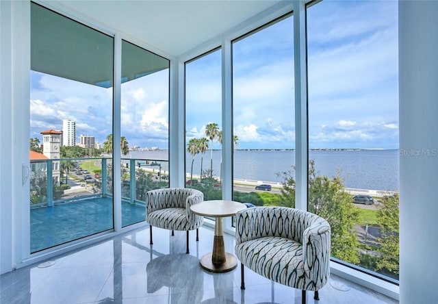 living area featuring a healthy amount of sunlight, expansive windows, and a water view