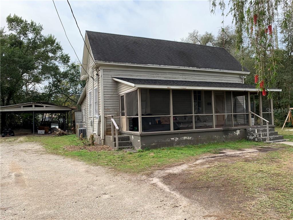 back of property with central AC unit and a sunroom