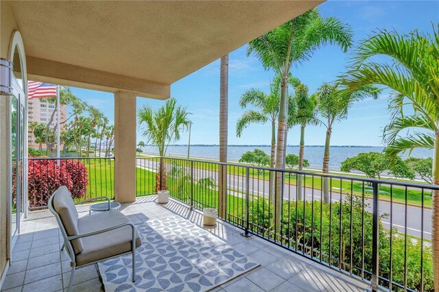 view of patio featuring a balcony and a water view