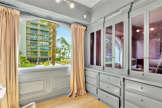 interior space with light hardwood / wood-style floors and ornamental molding