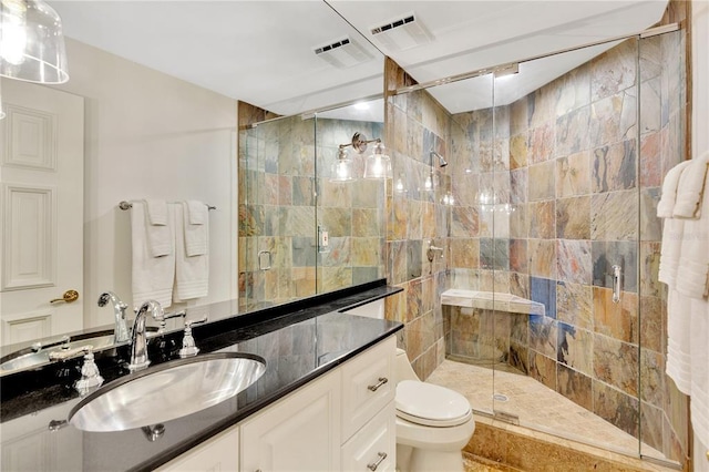 bathroom featuring toilet, a shower with door, and vanity