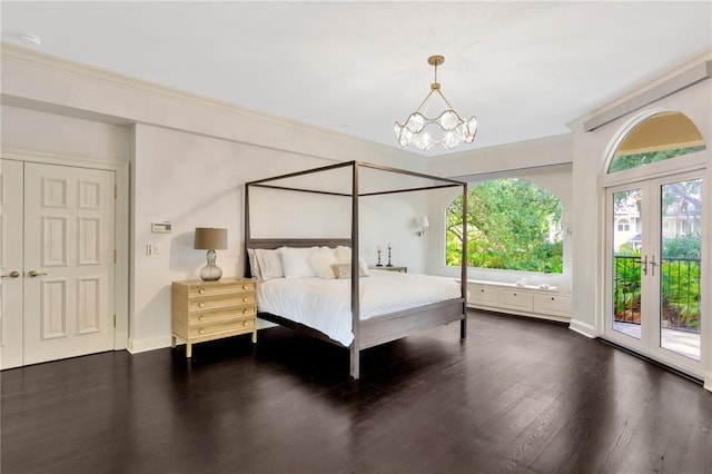 bedroom with a closet, access to exterior, a notable chandelier, french doors, and dark hardwood / wood-style flooring