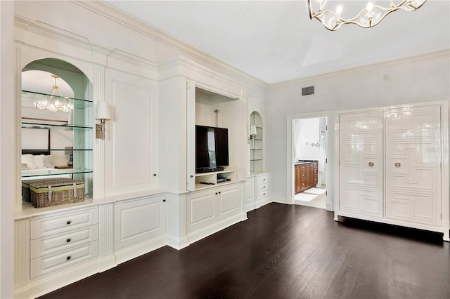 interior space featuring built in shelves, a notable chandelier, and dark wood-type flooring