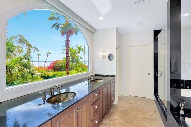 bathroom with walk in shower, tile flooring, dual sinks, and vanity with extensive cabinet space