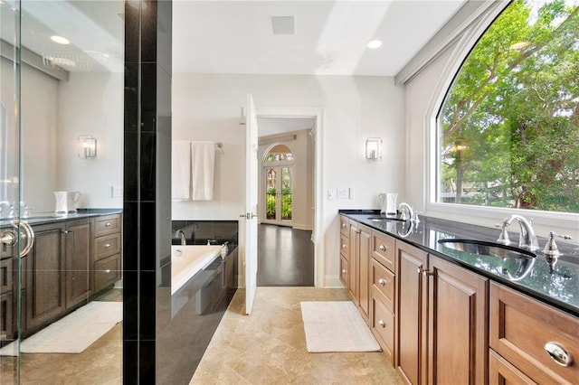 bathroom featuring double sink, a tub, tile flooring, and large vanity