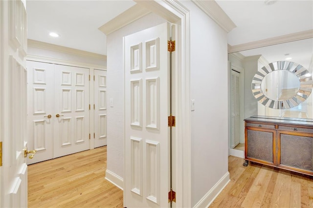 hallway with crown molding and light hardwood / wood-style flooring