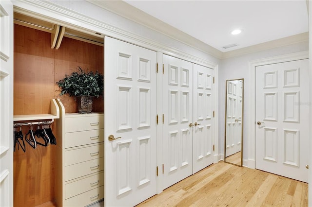 foyer with ornamental molding and light hardwood / wood-style flooring