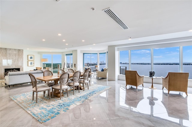 dining area featuring a high end fireplace and a water view