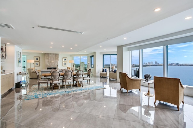 dining space featuring a water view and a large fireplace