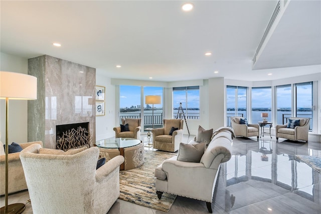 living room featuring a high end fireplace and a water view