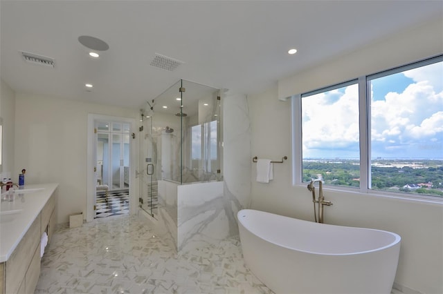 bathroom with vanity and shower with separate bathtub