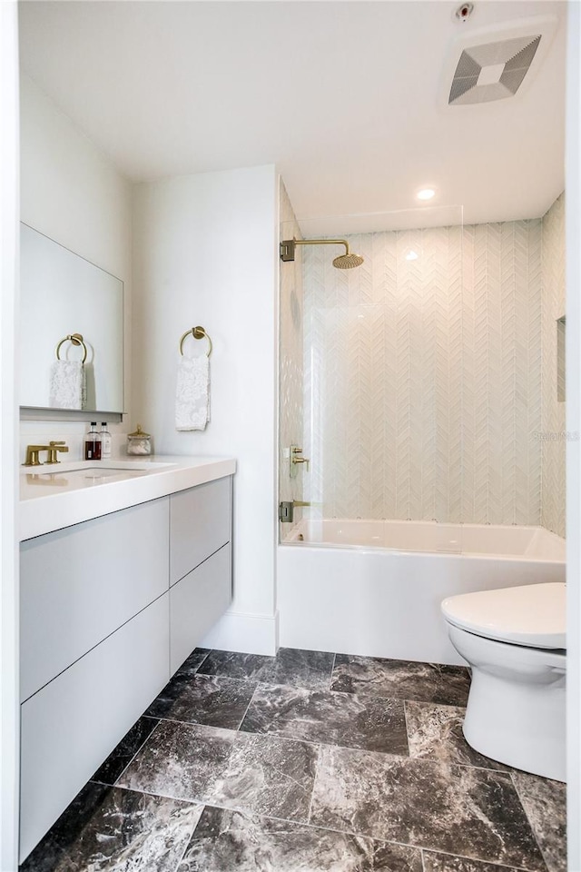 full bathroom with vanity, toilet, and tiled shower / bath combo