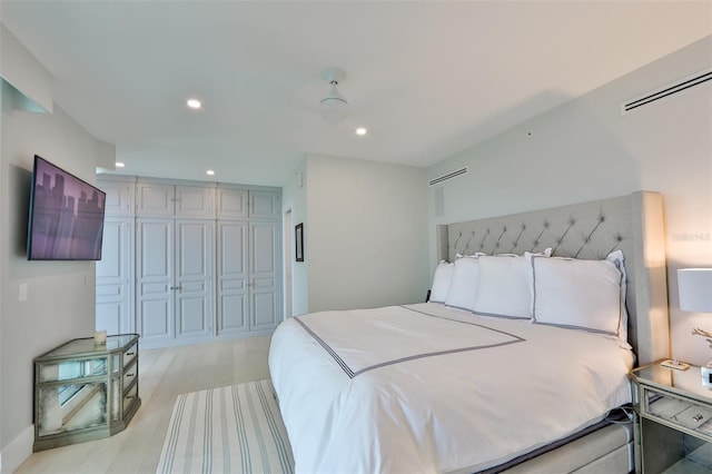 bedroom with light hardwood / wood-style floors and a closet