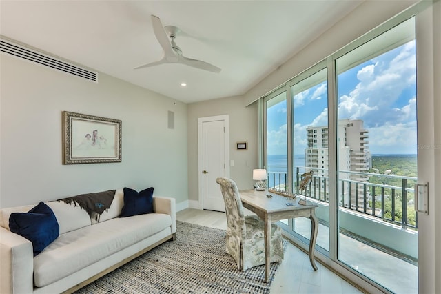 office space with a water view, ceiling fan, and light hardwood / wood-style flooring