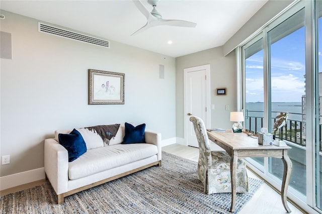 office space with a water view, ceiling fan, and hardwood / wood-style floors