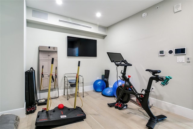 workout room with light hardwood / wood-style flooring