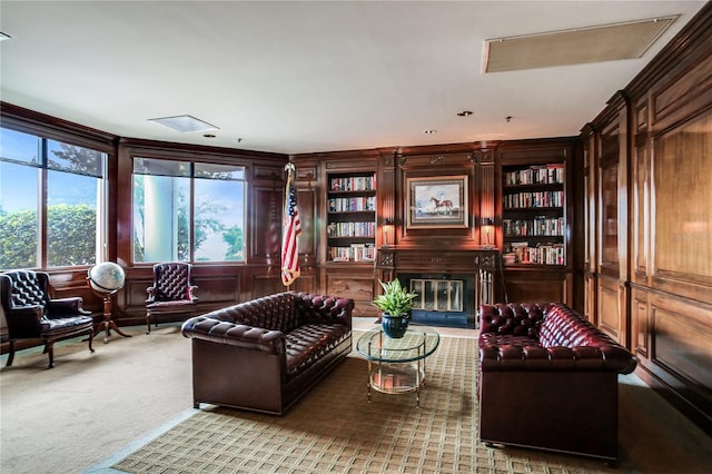 living area featuring light colored carpet and wood walls