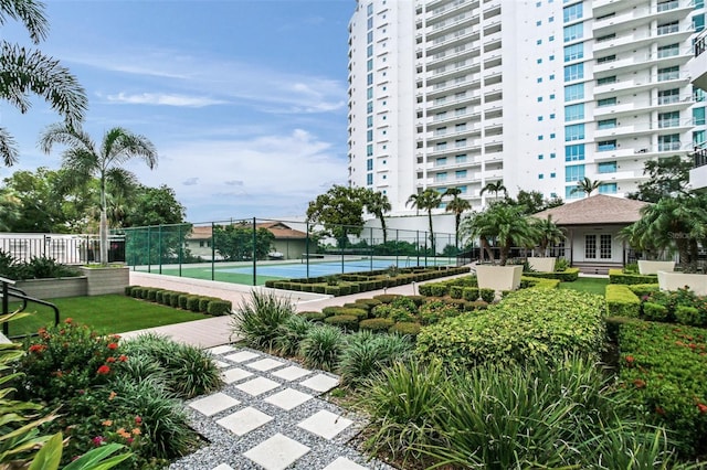 view of community featuring tennis court