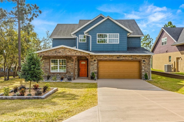 craftsman-style house featuring a front lawn, a garage, and central AC