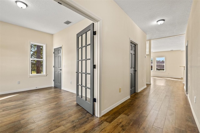 corridor featuring dark wood-type flooring and a textured ceiling