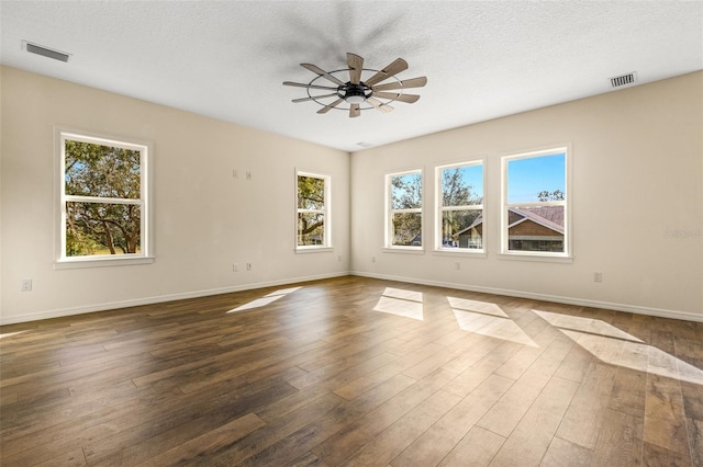 unfurnished room featuring dark wood-type flooring, a textured ceiling, and ceiling fan