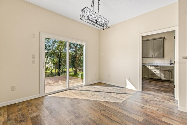 unfurnished dining area with sink and hardwood / wood-style flooring