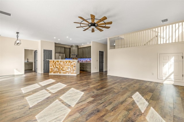 unfurnished living room with dark wood-type flooring and ceiling fan