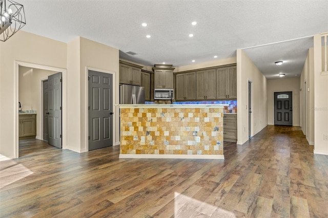 kitchen featuring a kitchen island, appliances with stainless steel finishes, a textured ceiling, dark hardwood / wood-style floors, and pendant lighting