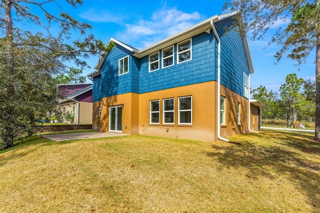 rear view of property with a lawn and a patio