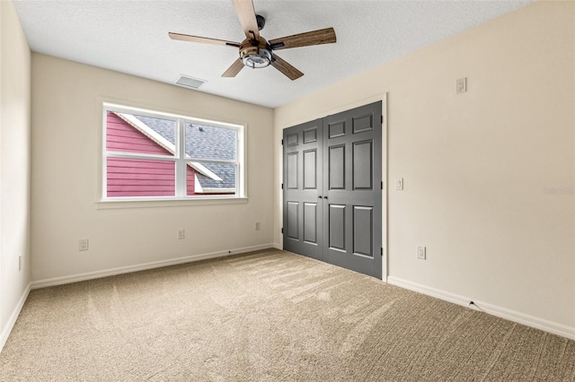 unfurnished bedroom with a closet, carpet, a textured ceiling, and ceiling fan