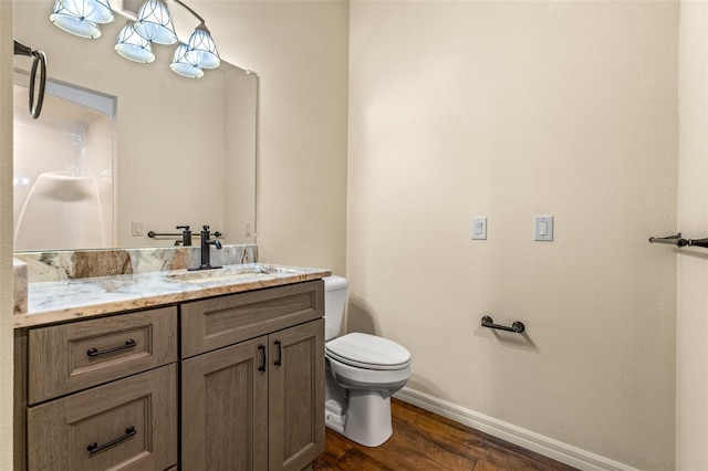 bathroom featuring toilet, vanity, and hardwood / wood-style flooring