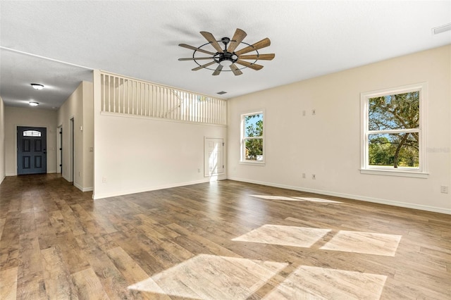 unfurnished living room with a textured ceiling, hardwood / wood-style floors, and ceiling fan